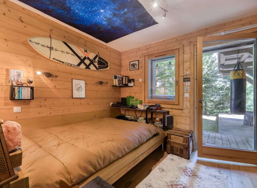 This cozy bedroom features a unique wooden interior and a stunning starry sky ceiling, creating a tranquil atmosphere.