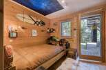 This cozy bedroom features a unique wooden interior and a stunning starry sky ceiling, creating a tranquil atmosphere.