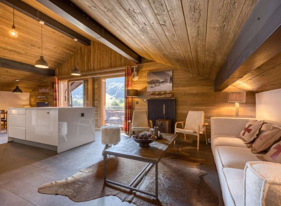 This stunning property boasts a cozy living space with a rustic wooden ceiling and walls, creating a warm and inviting atmosphere.