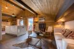 This stunning property boasts a cozy living space with a rustic wooden ceiling and walls, creating a warm and inviting atmosphere.