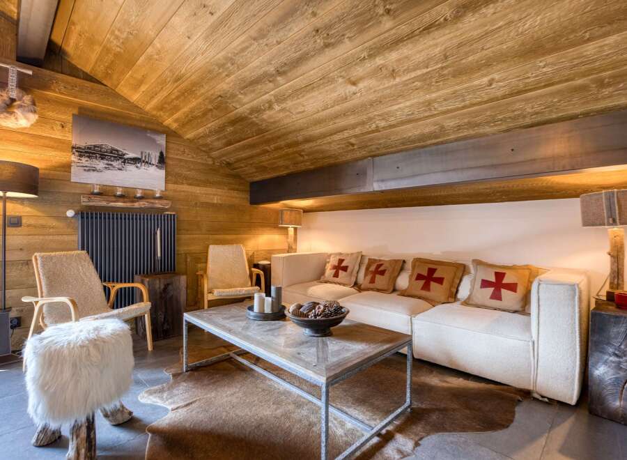 This cozy living room features a rustic wooden ceiling and walls, creating a warm and inviting atmosphere.