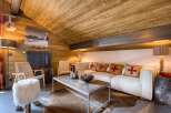 This cozy living room features a rustic wooden ceiling and walls, creating a warm and inviting atmosphere.