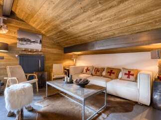 This cozy living room features a rustic wooden ceiling and walls, creating a warm and inviting atmosphere.