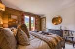 This cozy bedroom features rustic wood paneling and a luxurious faux fur throw, creating a warm and inviting atmosphere.