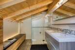 This stunning bathroom features a unique design with a wooden sloped ceiling, creating a warm and inviting atmosphere.
