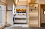This modern bathroom features a sleek design with a wooden slatted shower door and a skylight that floods the space with natural light.