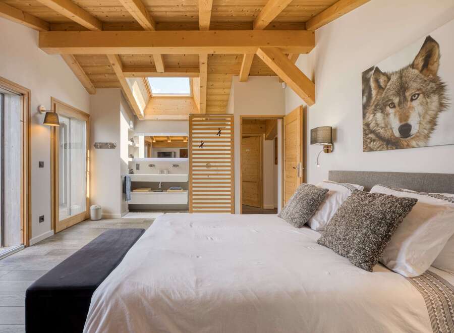 Experience luxury in this stunning bedroom featuring a unique wooden ceiling and a skylight that floods the space with natural light.