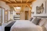 Experience luxury in this stunning bedroom featuring a unique wooden ceiling and a skylight that floods the space with natural light.