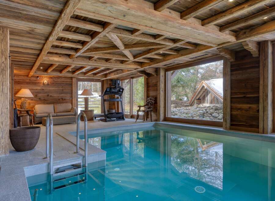 This luxurious indoor pool area boasts a rustic, yet elegant design.