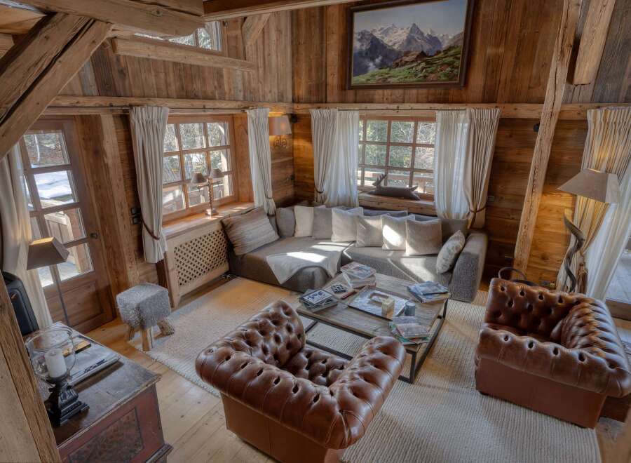 Step into a cozy chalet living room, showcasing rustic charm with exposed wooden beams and paneling.