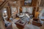 Step into a cozy chalet living room, showcasing rustic charm with exposed wooden beams and paneling.