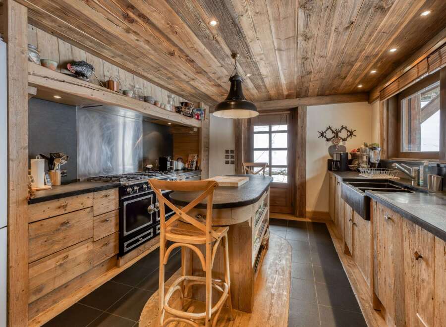 This stunning kitchen showcases rustic charm with its wooden ceiling, cabinets, and island.