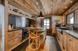 This stunning kitchen showcases rustic charm with its wooden ceiling, cabinets, and island.