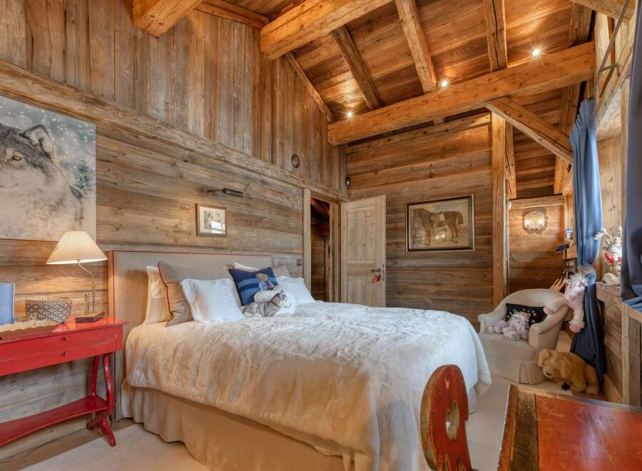 Experience rustic luxury in this stunning bedroom, featuring exquisite wooden paneling and a cozy ambiance.