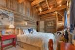 Experience rustic luxury in this stunning bedroom, featuring exquisite wooden paneling and a cozy ambiance.