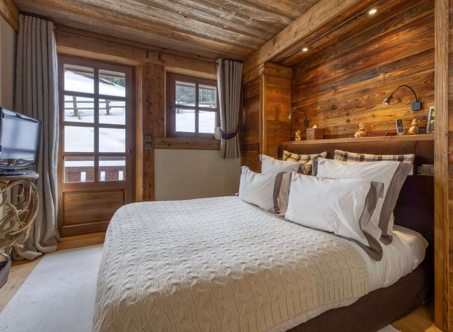 Experience the warmth of this cozy bedroom, featuring rustic wooden accents and a serene ambiance.