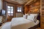 Experience the warmth of this cozy bedroom, featuring rustic wooden accents and a serene ambiance.