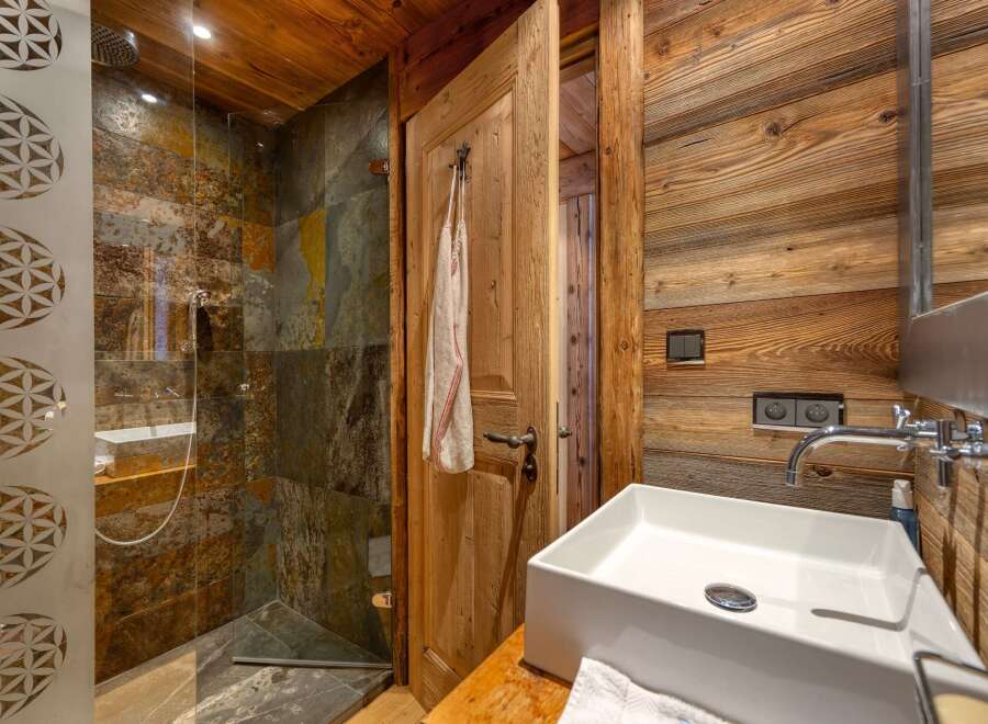 This rustic bathroom features a stunning wooden design, creating a warm and inviting atmosphere.