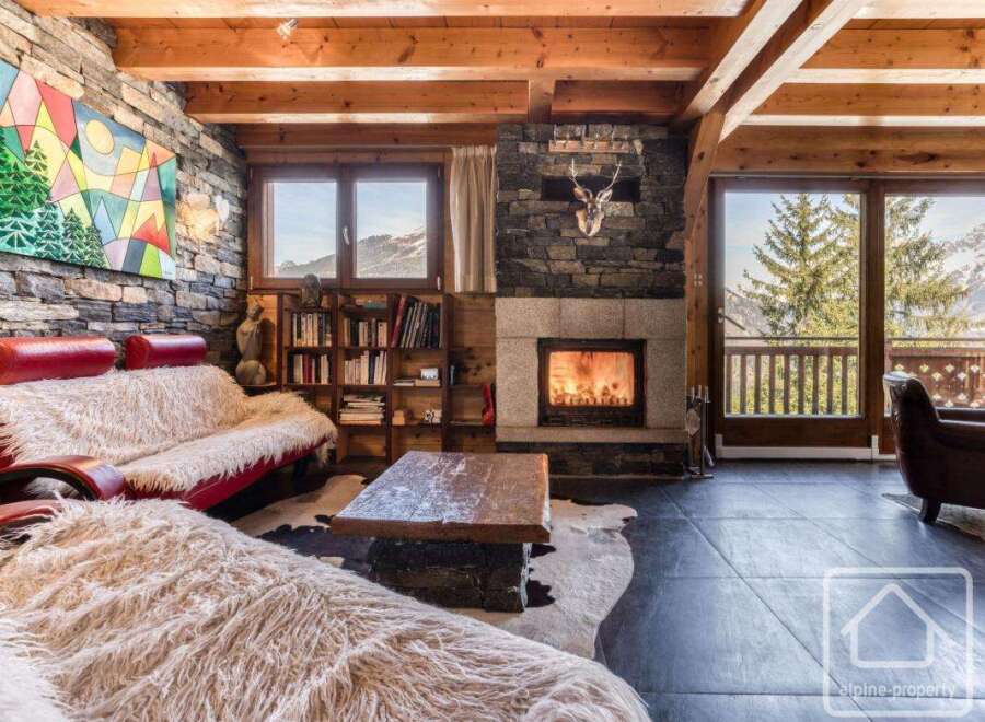 Experience the epitome of alpine luxury in this stunning property, boasting a cozy living room with a fireplace and a plush sofa.