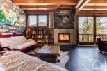 Experience the epitome of alpine luxury in this stunning property, boasting a cozy living room with a fireplace and a plush sofa.