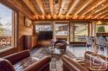 Experience the charm of this stunning property, featuring a cozy living room with exposed wooden beams and a breathtaking mountain view.