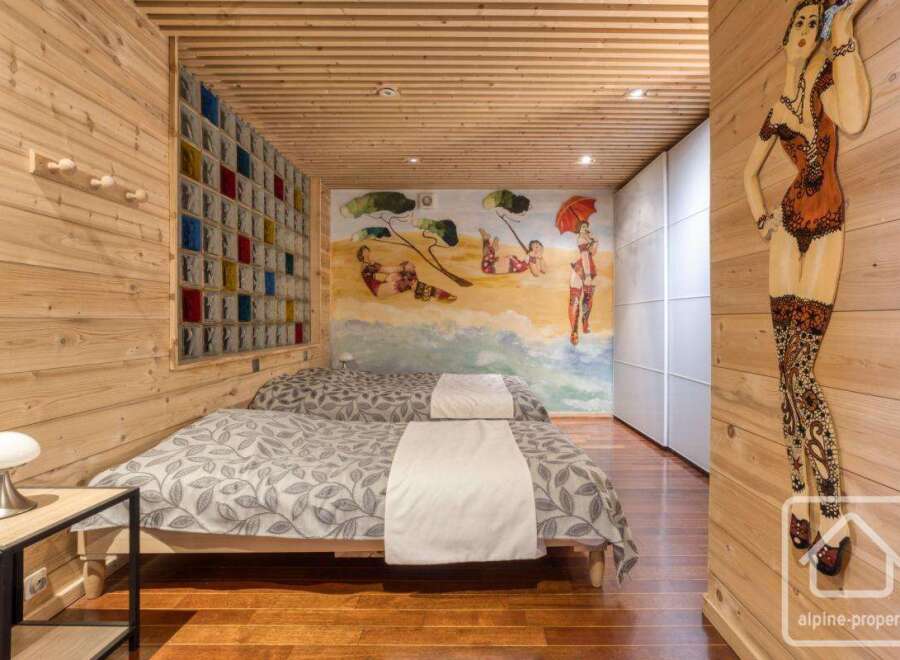 This cozy bedroom features a unique wooden design with a touch of artistic flair.