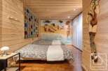 This cozy bedroom features a unique wooden design with a touch of artistic flair.