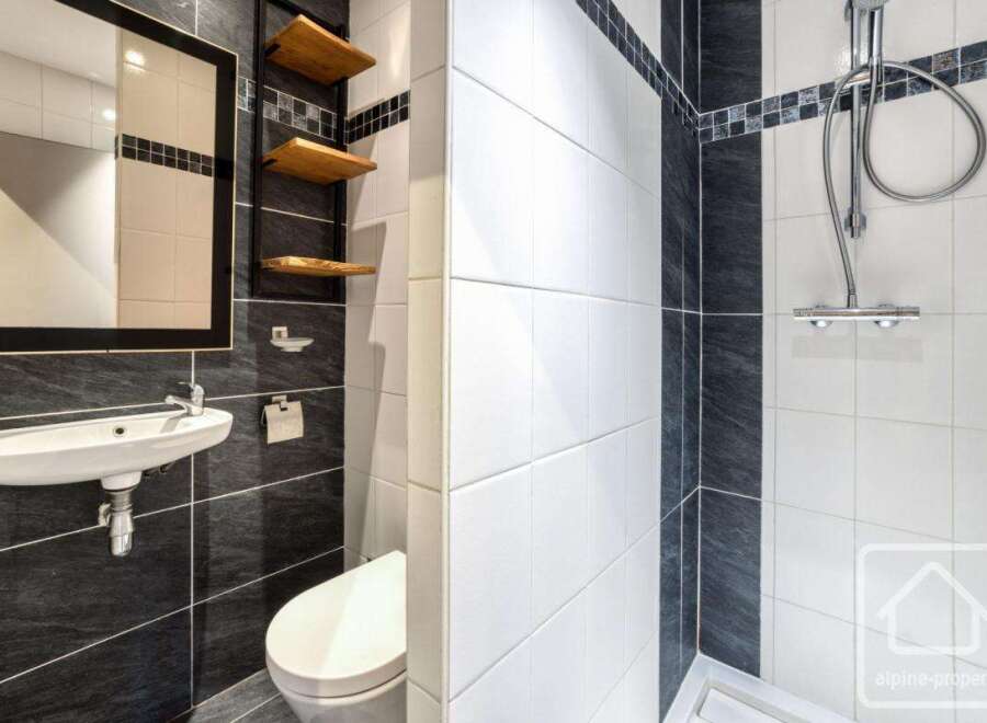 This modern bathroom features a sleek design with contrasting black and white tiles.
