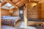 Discover the charm of this cozy bedroom, featuring stunning wooden paneling and a unique skylight that floods the space with natural light.