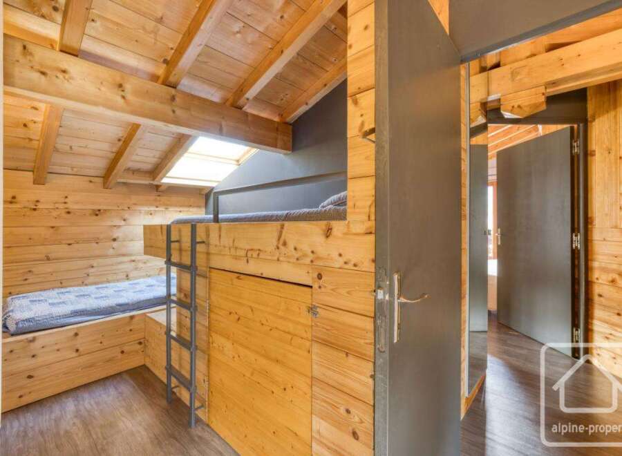 This cozy cabin bedroom features a unique bunk bed design, perfect for maximizing space.