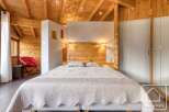 This cozy bedroom features a wooden ceiling and walls, creating a warm and inviting atmosphere.