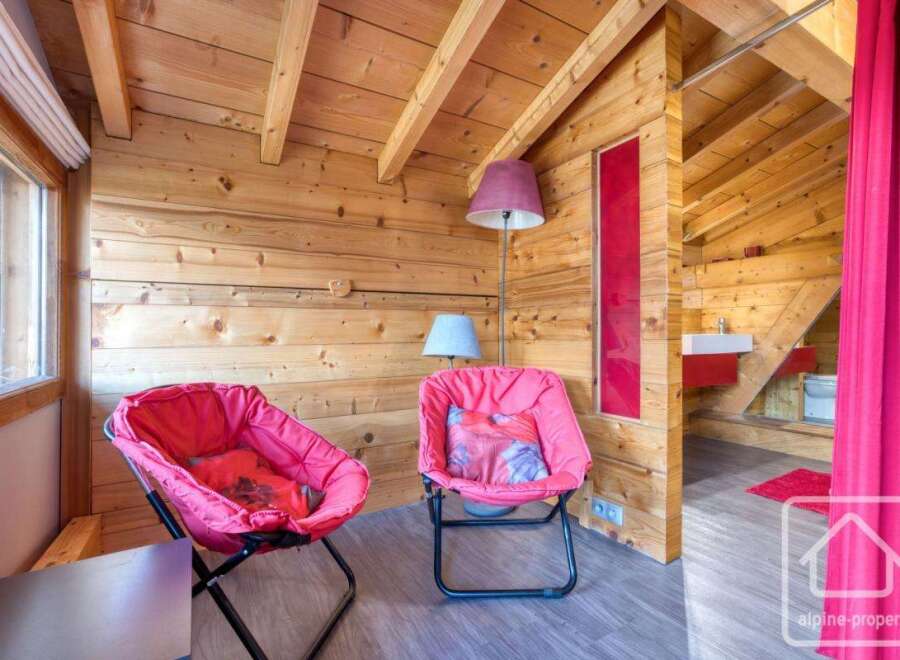Discover the charm of this cozy property, featuring a unique wooden interior and inviting seating areas.