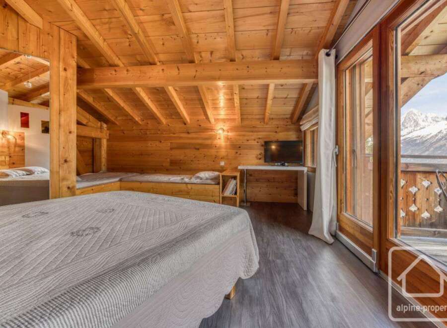Experience the charm of this cozy alpine property, featuring a warm wooden interior and stunning mountain views.