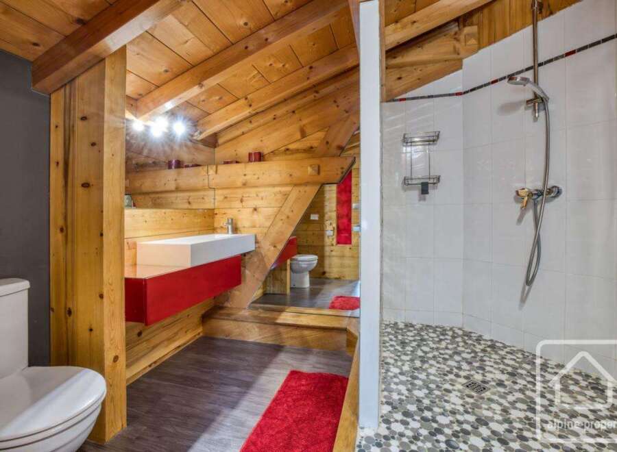 This unique bathroom features a stunning wooden ceiling and walls, creating a warm and inviting atmosphere.