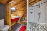 This unique bathroom features a stunning wooden ceiling and walls, creating a warm and inviting atmosphere.