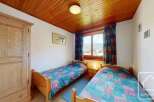 This charming bedroom features two single beds, perfect for guests or family.