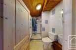 Step into this charming bathroom, featuring a cozy wooden ceiling and walls that exude warmth.