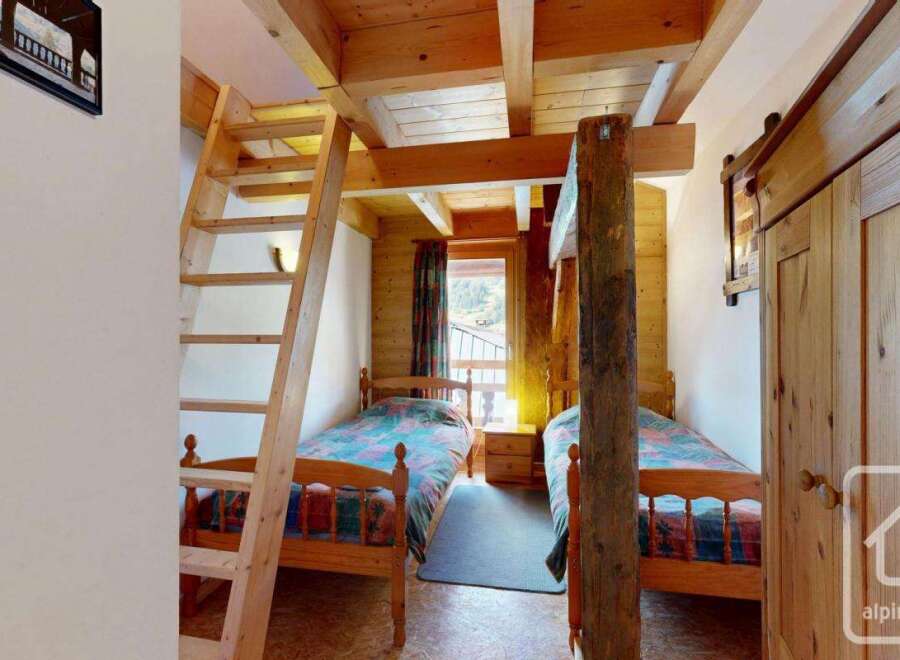 Discover a cozy bedroom featuring two single beds, perfect for a family or group of friends.