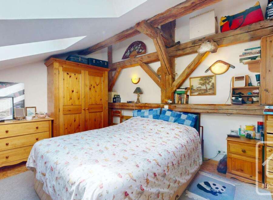 This charming bedroom features exposed wooden beams, adding rustic character to the space.