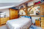 This charming bedroom features exposed wooden beams, adding rustic character to the space.