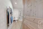 Discover this charming bathroom featuring a modern shower, a convenient toilet, and a stylish towel rack.