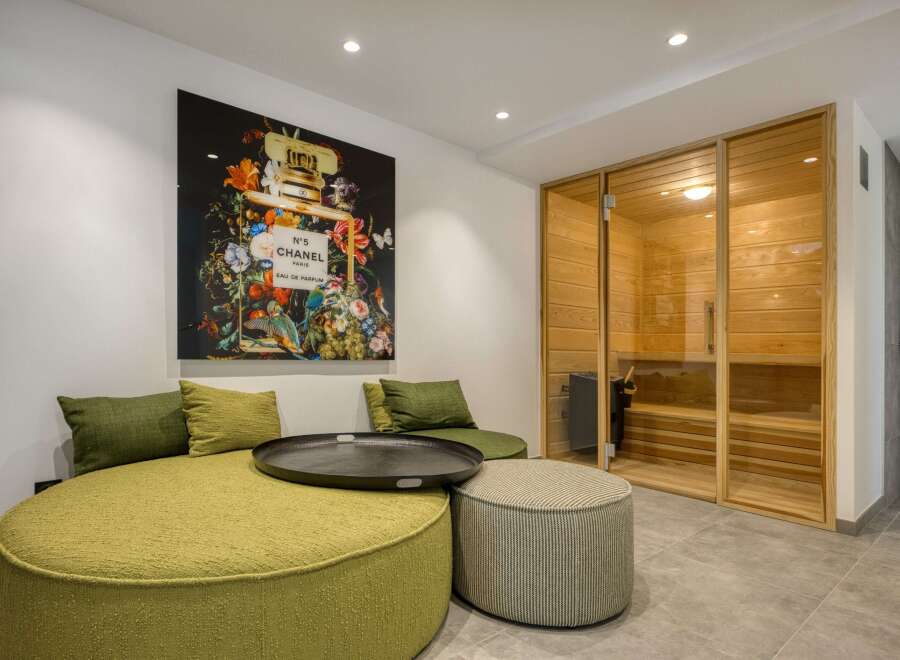 This luxurious space features a comfortable seating area with a stylish round sofa and decorative pillows, perfect for relaxation.