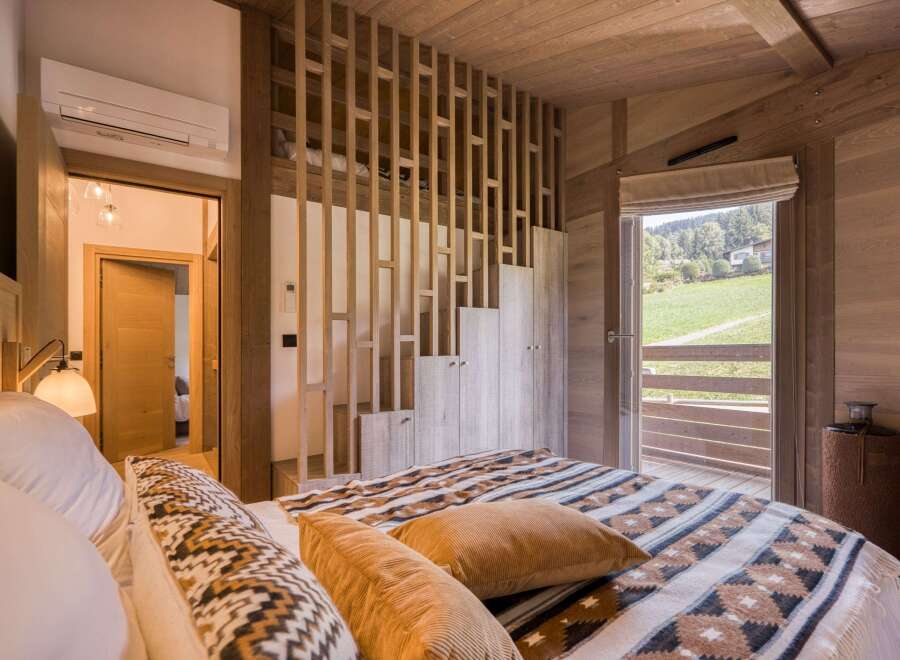 Experience the tranquility of this stunning bedroom, featuring a cozy bed adorned with stylish blankets and pillows.