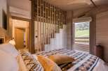 Experience the tranquility of this stunning bedroom, featuring a cozy bed adorned with stylish blankets and pillows.