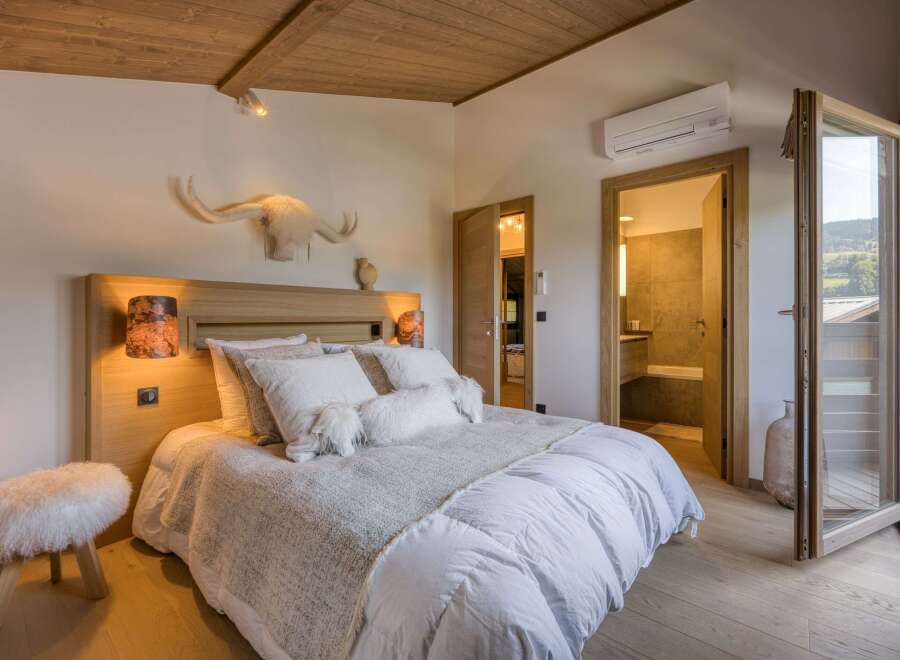 Experience luxury in this stunning bedroom featuring a cozy bed with plush pillows and a stylish headboard.