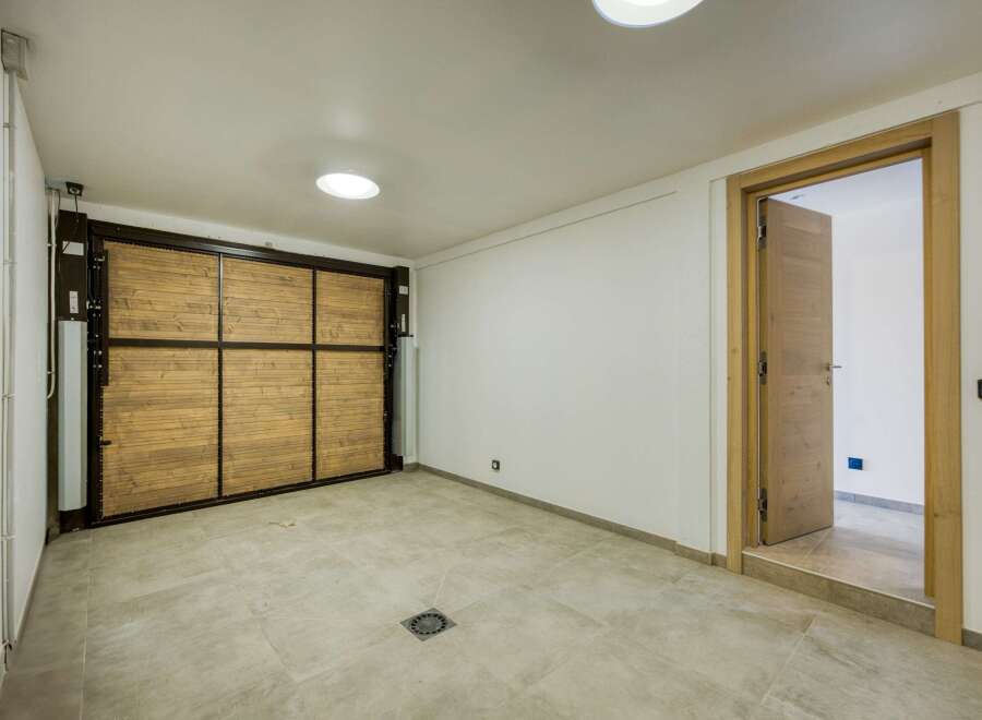 This spacious interior features a unique wooden garage door, adding a touch of rustic charm.
