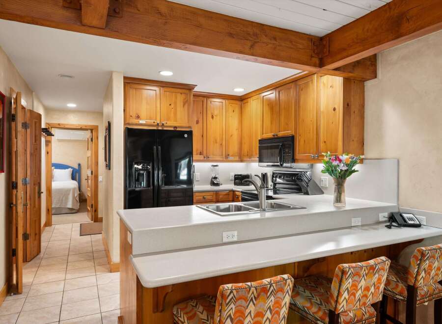 This stunning kitchen boasts beautiful wooden cabinetry and a sleek, modern countertop, perfect for culinary enthusiasts.