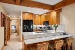 This stunning kitchen boasts beautiful wooden cabinetry and a sleek, modern countertop, perfect for culinary enthusiasts.