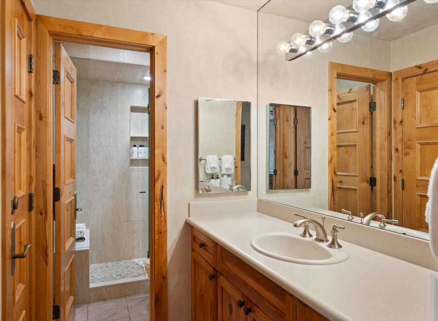 This luxurious bathroom features a spacious vanity with a sleek countertop and a stylish sink.