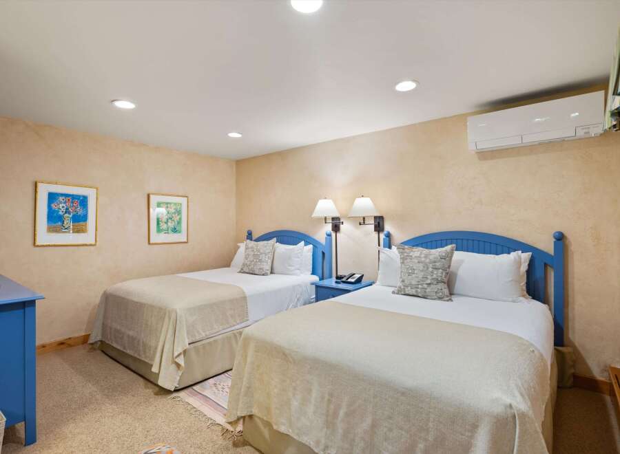 This charming bedroom features two comfortable beds with cozy bedding, perfect for a relaxing stay.